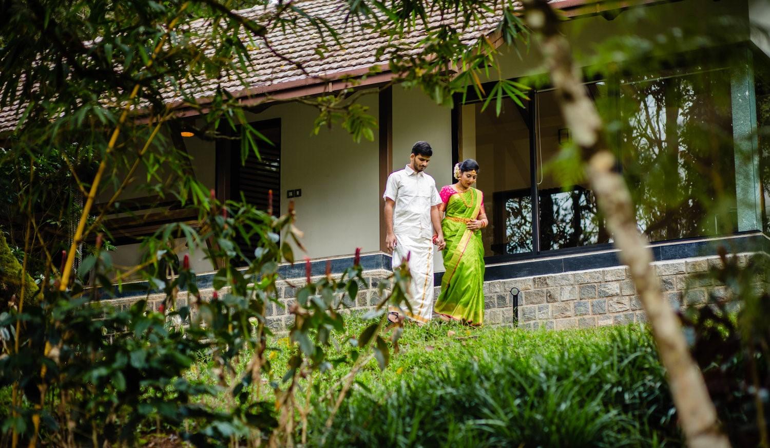A couple-to-be walking by their cottage at the Ibnii Coorg Resort